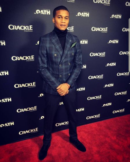Cory Hardrict in a black suit poses during a public event.
